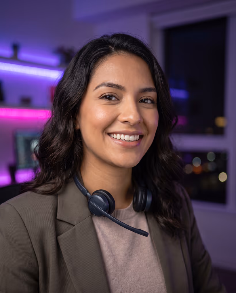 A virtual assistant with a headset around her neck, smiling at the camera